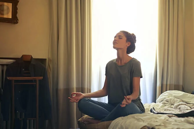 Girl meditating on a bed