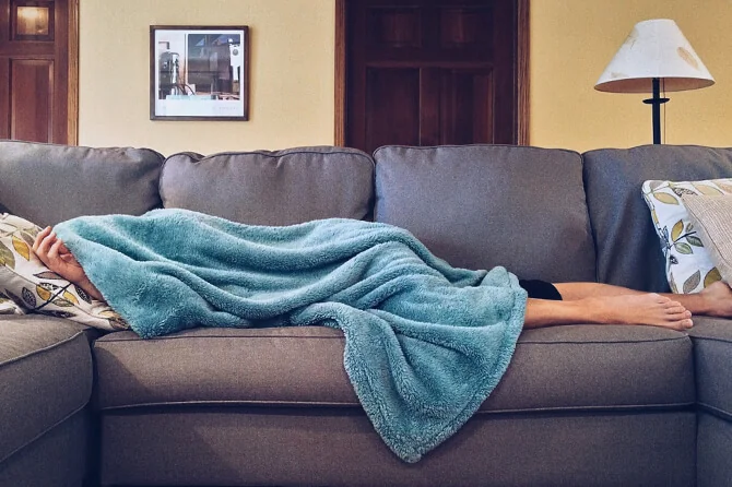 having a nap on the sofa with a blanket over the head