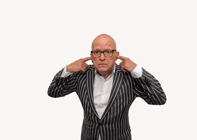 man with fingers in his ears
