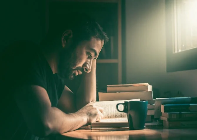 man reading a book in soft daylight