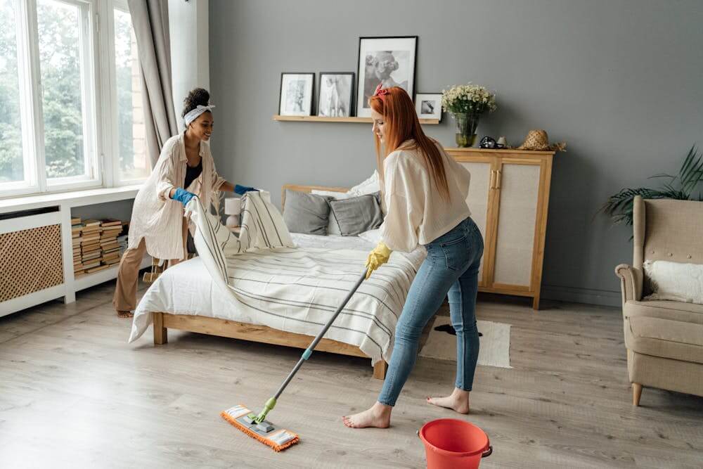 women spring cleaning their bedroom
